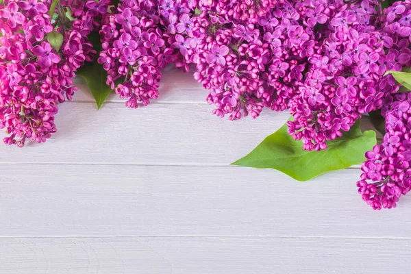 Beyaz ahşap bir masada güzel mor leylak çiçekleri.