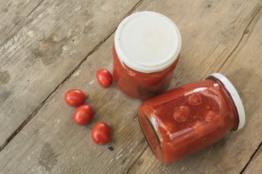 Tomatoes preserved in glass jars clipart