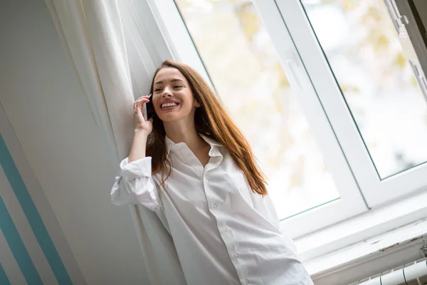 Beautiful woman using phone in house