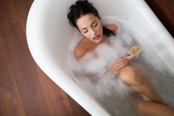 Hermosa mujer disfrutando de un baño de burbujas — Foto de Stock