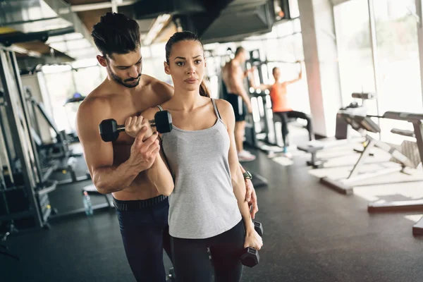 Beautiful woman helped by trainer — Stock Photo, Image