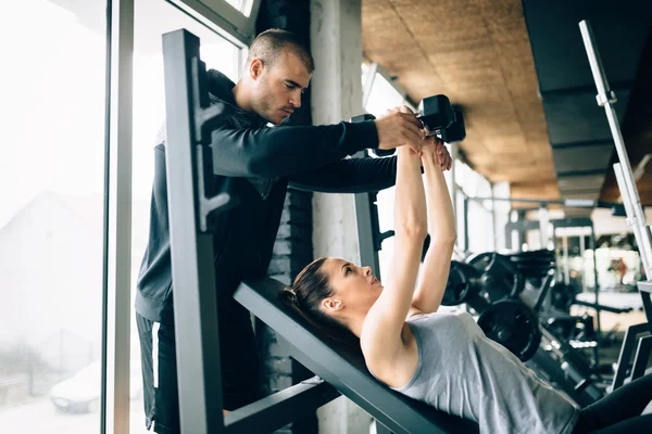 Mooie vrouw geholpen door trainer — Stockfoto