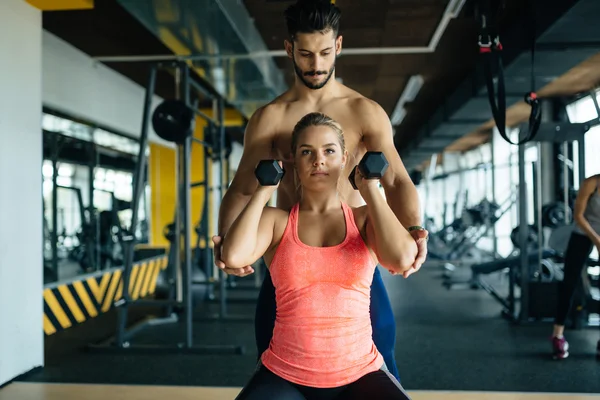 Personal trainer helping woman — Stock Photo, Image