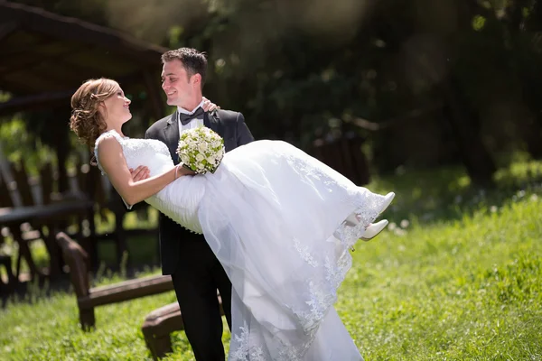 Sposo che porta sposa all'aperto — Foto Stock