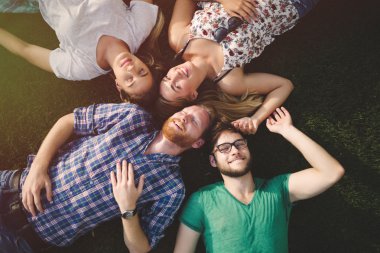 Bir grup insan çim üzerinde yalan