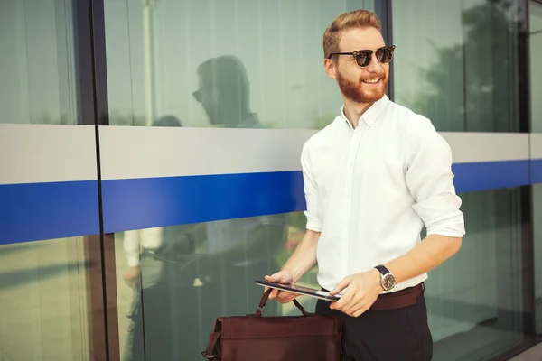 Businessman holding bad and tablet