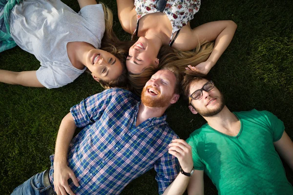 Gruppo di persone sdraiate sull'erba — Foto Stock