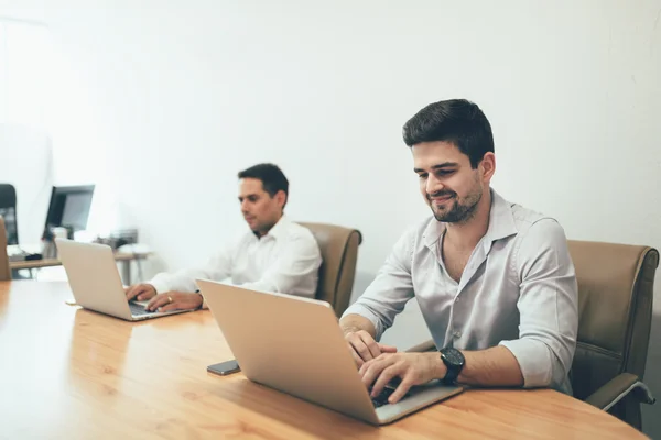 Menschen, die im Büro an Laptops arbeiten — Stockfoto