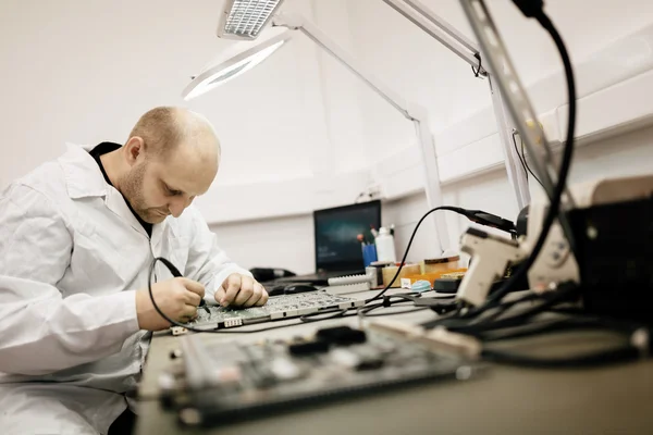 Technicus fixing moederbord door solderen — Stockfoto