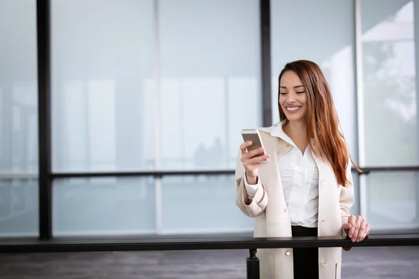 Gülümseyen ve telefon kullanarak iş kadını — Stok fotoğraf