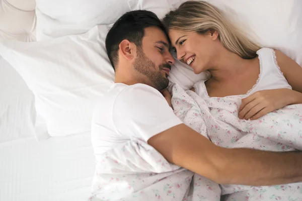 Casal romântico na cama em roupa de noite — Fotografia de Stock