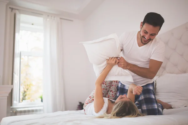 Hermosa pareja luchando almohadas — Foto de Stock