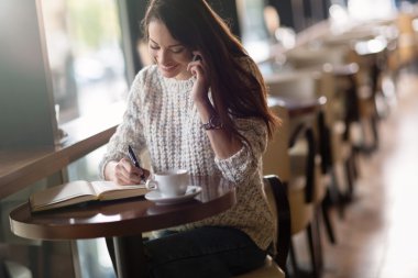 Çalışma ve kafede okuyan güzel kadın