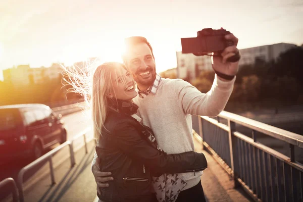 Pareja feliz tomando selfies en la ciudad — Foto de Stock