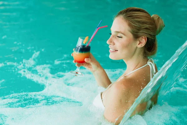Mujer disfrutando de la hidroterapia y cóctel — Foto de Stock