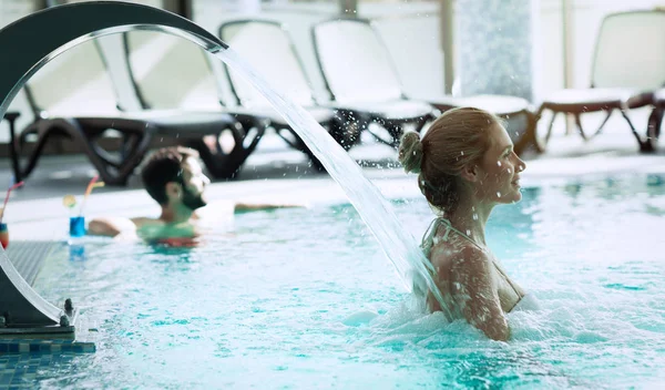 Mujer disfrutando de la hidroterapia en la piscina spa — Foto de Stock