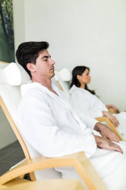 Yakışıklı bir adam dinlendirici bir spa, bir sandalyede
