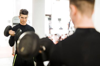 Bir spor salonunda egzersiz ve ağırlık kaldırma genç kaslı adam