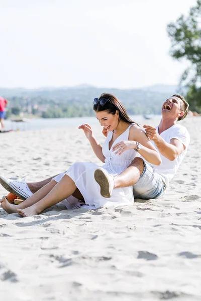 Romantyczna młoda para siedzi przy plaży — Zdjęcie stockowe
