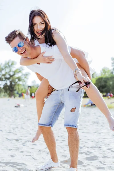 Casal apaixonado desfrutando de suas férias de verão como o homem carrega — Fotografia de Stock