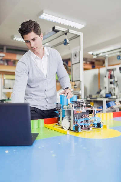 Ingénieur électricien programmant un robot pendant les cours de robotique — Photo