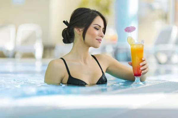 Linda senhora bebendo um coquetel em uma piscina — Fotografia de Stock