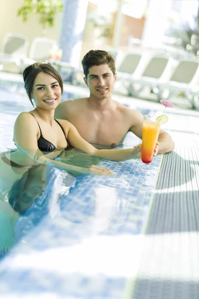 Par som dricker en cocktail vid poolen — Stockfoto