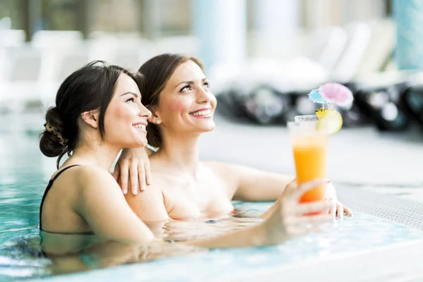 Krásné mladé ženy, pití koktejly v bazénu — Stock fotografie