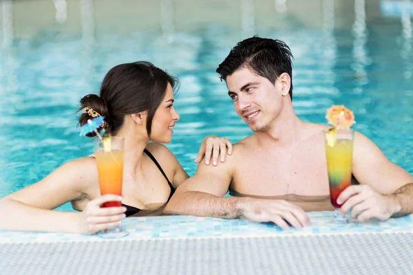 Par som dricker en cocktail vid poolen — Stockfoto