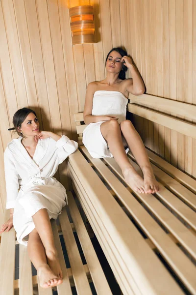 Two beautiful women relaxing in a sauna — Stock Photo, Image