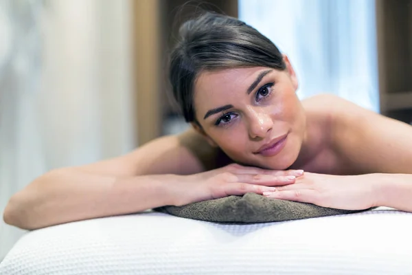 Mulher bonita deitada em uma mesa de massagem e relaxante — Fotografia de Stock