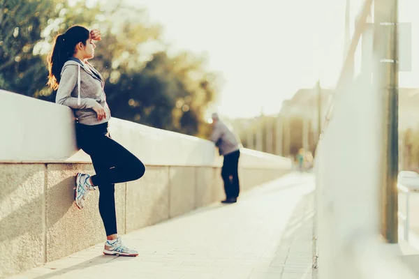 Όμορφη γυναίκα που αναπαύεται στην πόλη μετά από τρέξιμο — Φωτογραφία Αρχείου