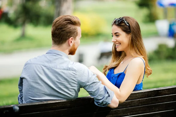 Namoro casal sentado no banco — Fotografia de Stock