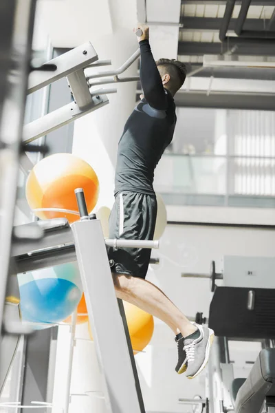 Joven hombre guapo haciendo ejercicio en un gimnasio —  Fotos de Stock