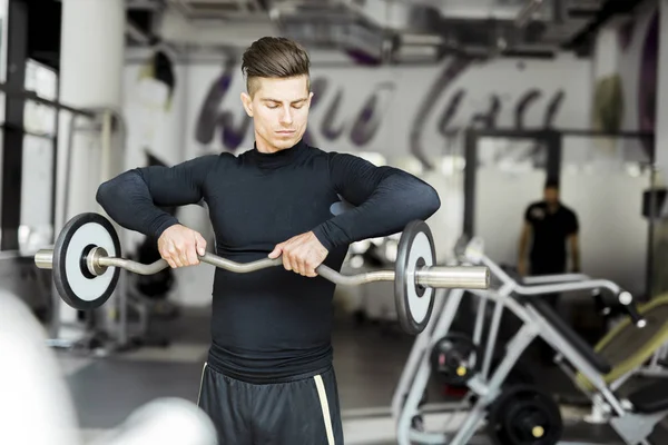 Hombre joven entrenando en un gimnasio —  Fotos de Stock