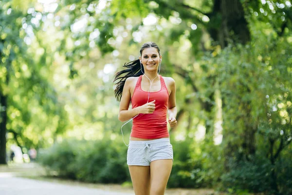 Jonge mooie atleet joggen in het park — Stockfoto