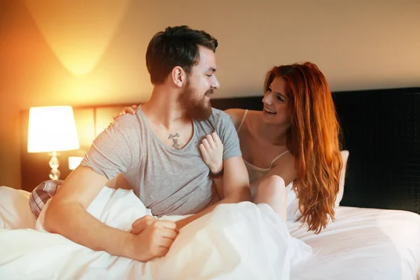 Lyckliga par i sängen visar känslor — Stockfoto