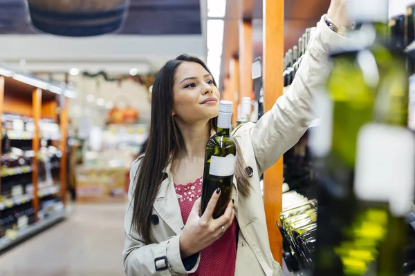 Asszony úgy döntött, hogy milyen bort vásárolni — Stock Fotó