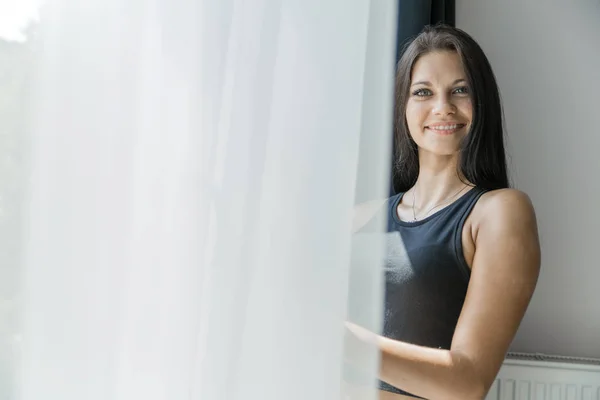 Mujer de pie cerca de ventana —  Fotos de Stock