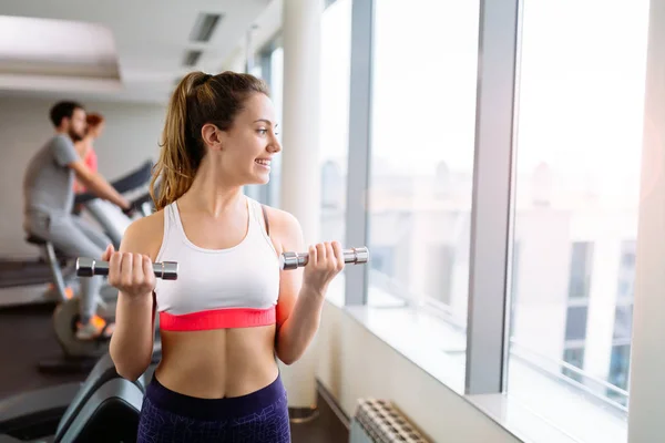 Vrouw tillen gewichten in gym — Stockfoto