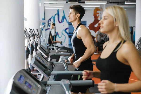 Spor salonunda koşu bandı üzerinde çalışan insanlar — Stok fotoğraf