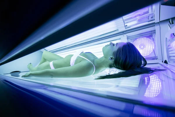 Beautiful brunette sunbathing in solarium — Stock Photo, Image