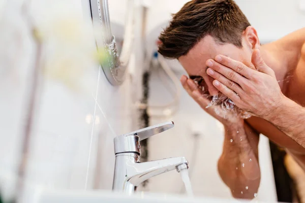 Mann som vasker ansiktet om morgenen – stockfoto