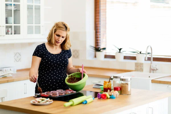 Hermosa mujer embarazada preparando magdalenas —  Fotos de Stock