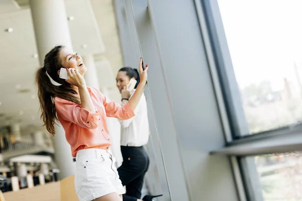 Mulheres bonitas usando telefones — Fotografia de Stock