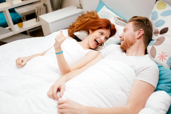 Beau couple souriant au lit — Photo