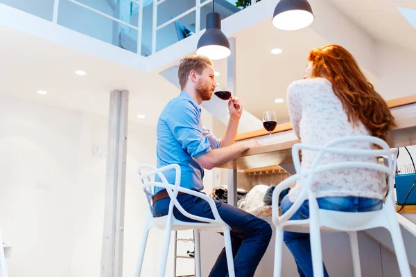 Mooie paar drinken van wijn in woonkamer — Stockfoto