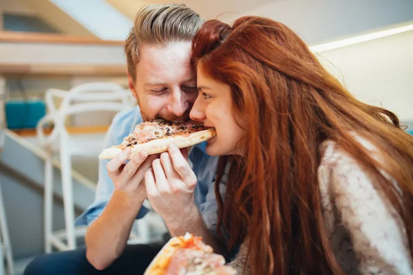 Pasangan berbagi pizza dan makan — Stok Foto