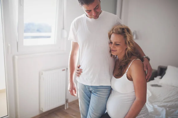 Šťastný manžel a těhotná žena v domácnosti — Stock fotografie