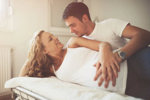 Glad man och gravida hustru hemma — Stockfoto